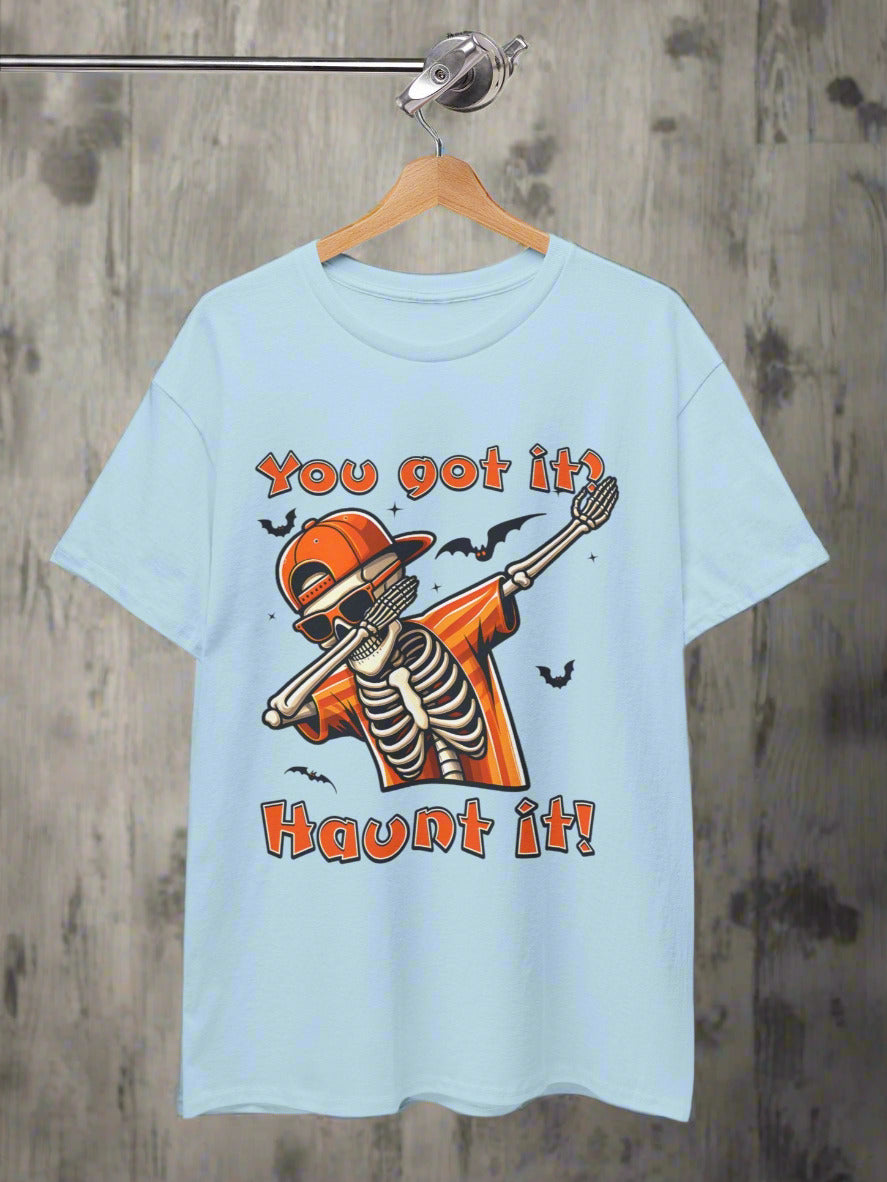 Light blue t-shirt with skeleton graphic and text 'You got it? Haunt it!' on a wooden background