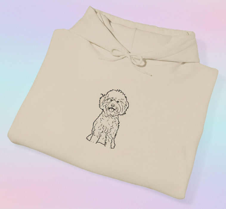 Folded beige sweatshirt with a dog illustration on a pastel background