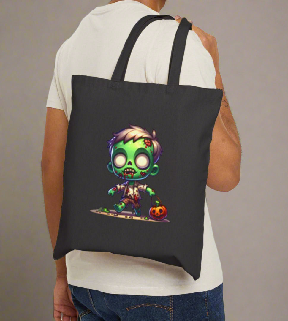 Person holding a black tote bag with a colorful zombie design on a plain background