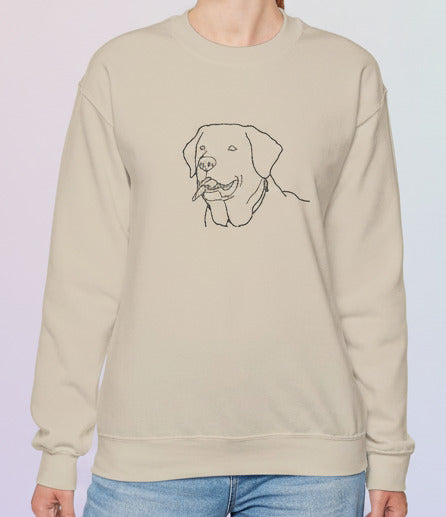 Woman wearing a beige sweatshirt with a dog illustration on a pastel background
