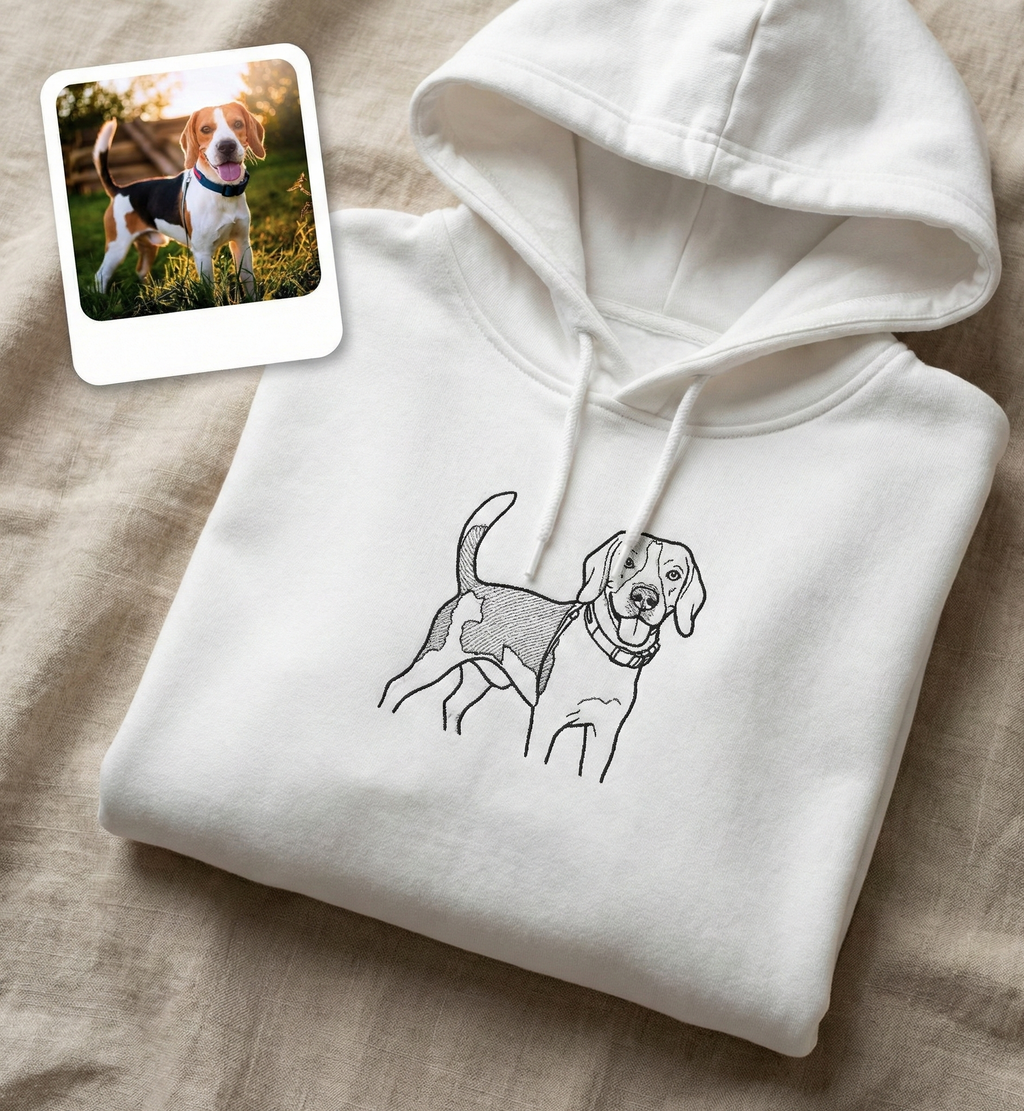 White hoodie with dog illustration and inset photo of a beagle on a beige surface